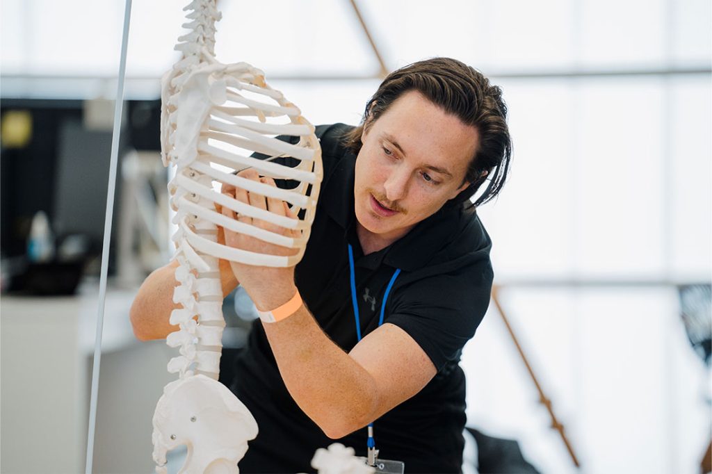 Exercise physiologist using a skeleton to teach and explain